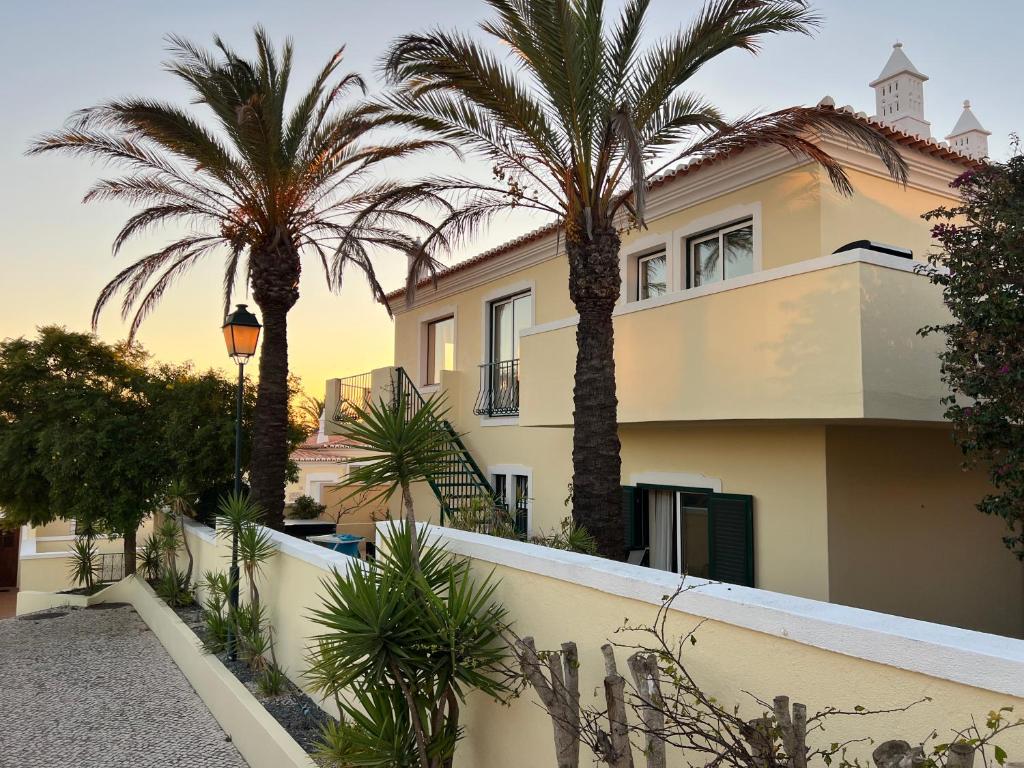 Vila Castelo Haus 28 mit Palmen im warmen Abendlicht